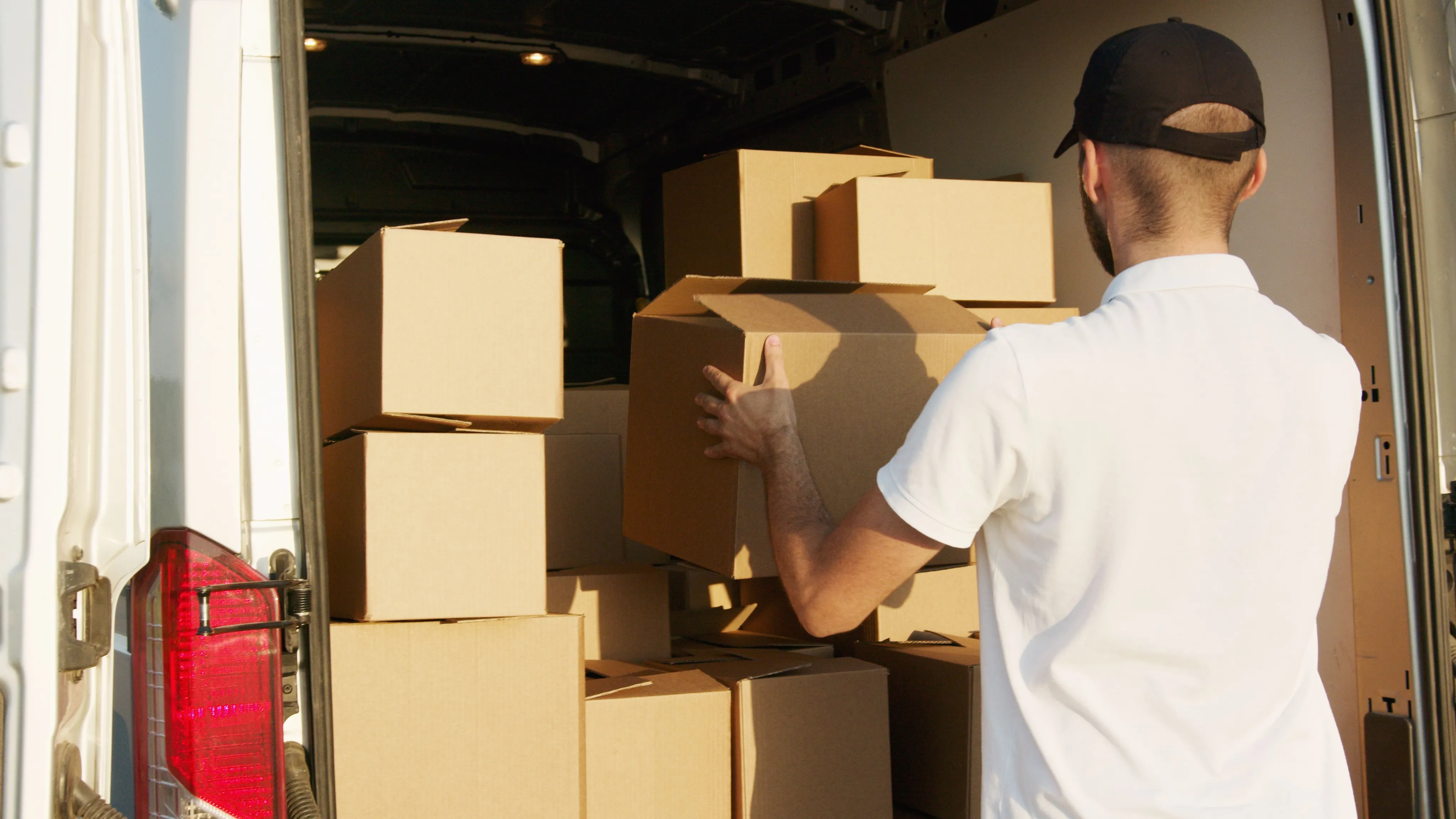 A courier stacking parcels into a van